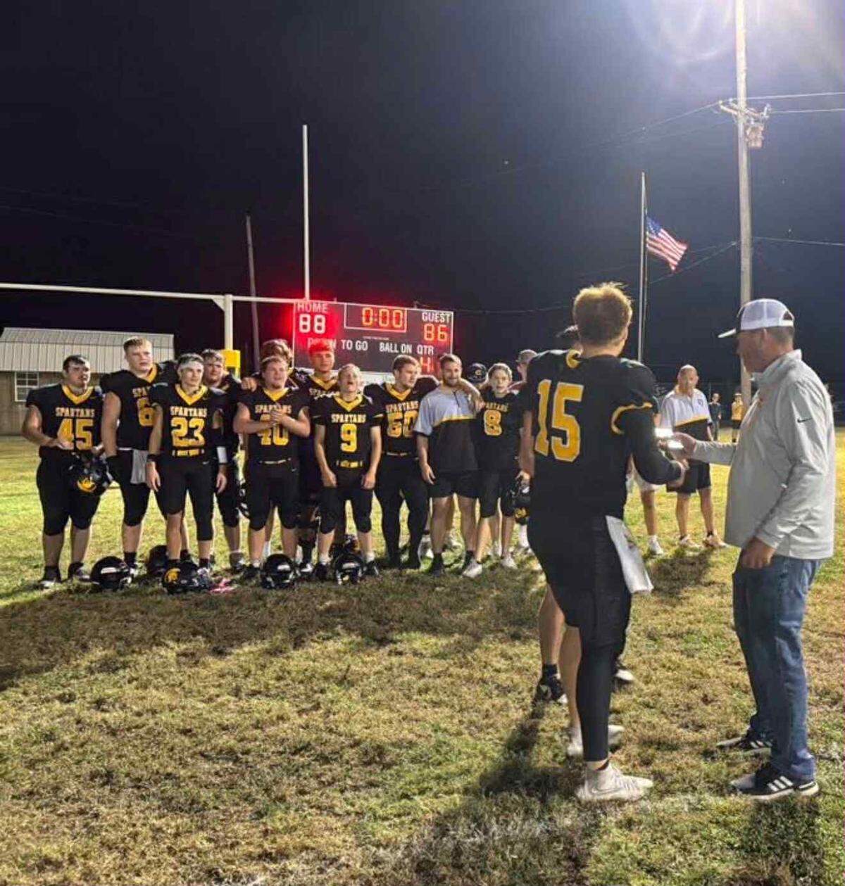 Cedar Vale-Dexter football players Cooper Criss and Royce Potter receive the District 1 championship plaque after the Spartans won 88-86 over Oswego on Friday night.