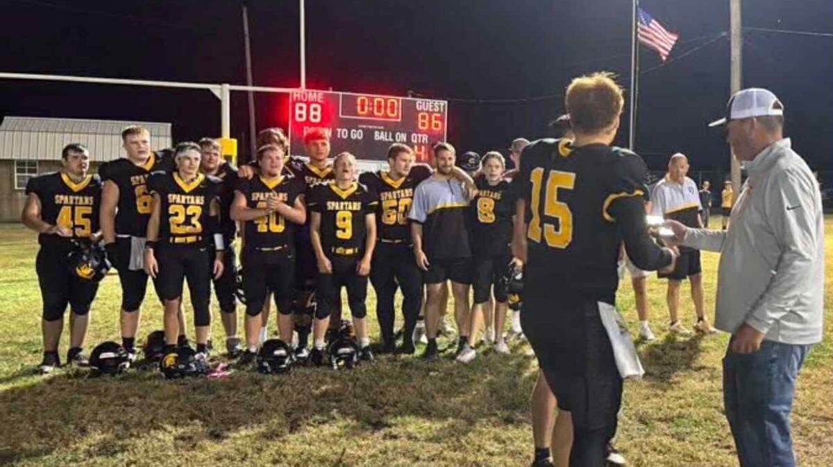 Cedar Vale-Dexter football players Cooper Criss and Royce Potter receive the District 1 championship plaque after the Spartans won 88-86 over Oswego on Friday night.