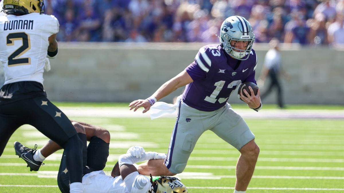 Sep 27, 2025; Manhattan, Kansas, USA; Kansas State Wildcats quarterback Blake Barnett (13) is tackled by UCF Knights defensive back Braeden Marshall (4) during the second quarte at Bill Snyder Family Football Stadium. Mandatory Credit: Scott Sewell-Imagn Images