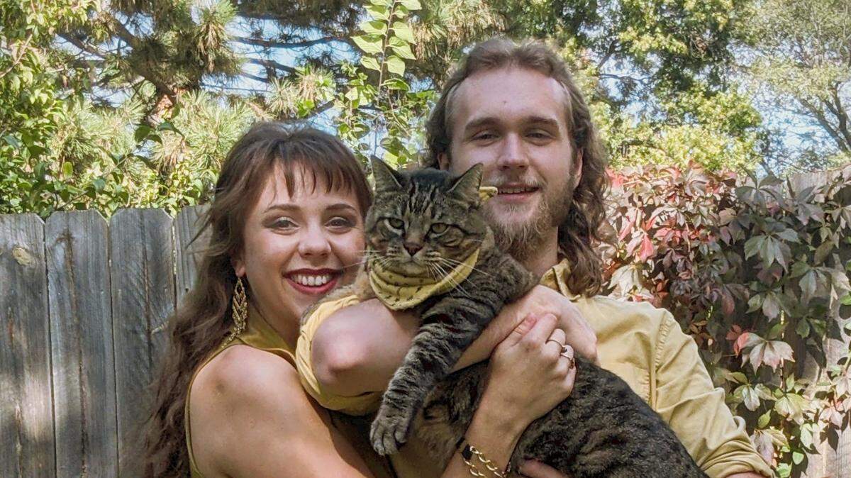 Julia Hardenburger and Noah Souza with Snicker, their late cat who is the inspiration for their new Snick’s Cat Cafe.