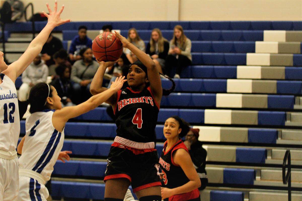 Wichita Heights junior guard Taylor Jameson shoots in the face of two defenders during the Falcons’ 60-43 win over Kapaun Mt. Carmel on Tuesday night. (Jan. 22, 2019)