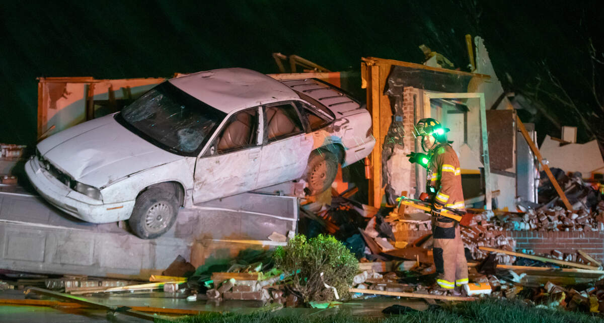 Firefighters search a home on south Hedgewood Street in Andover on Friday night after a tornado ripped through the area.