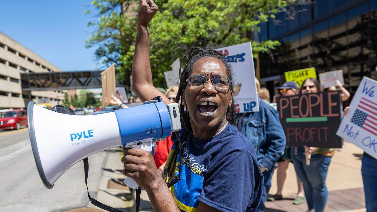 Mitchele Smith yells through a megaphone during a protest in downtown Wichita on May 1. A crowd of people gathered at the corner of Douglas and Broadway, as they have been on recent Saturdays and Mondays, to protest Trump administration policies.