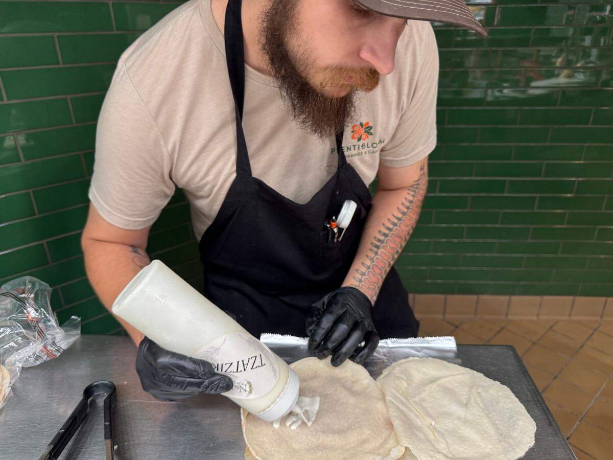 An employee prepares an N&J chicken shawarma wrap at the new Plentibloom Market & Cafe inside the Ruffin Building at Douglas and Broadway.