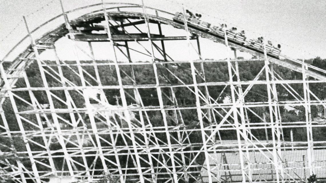 Kids ride the Ferris wheel as riders near the top of the roller coaster in the background in this photo from 1983.