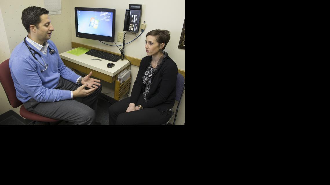 Marcie Kelly, a 33-year-old melanoma patient, visits with oncologist Chris Dakhil on Wednesday. Kelly is taking part in a clinical drug trial. 


