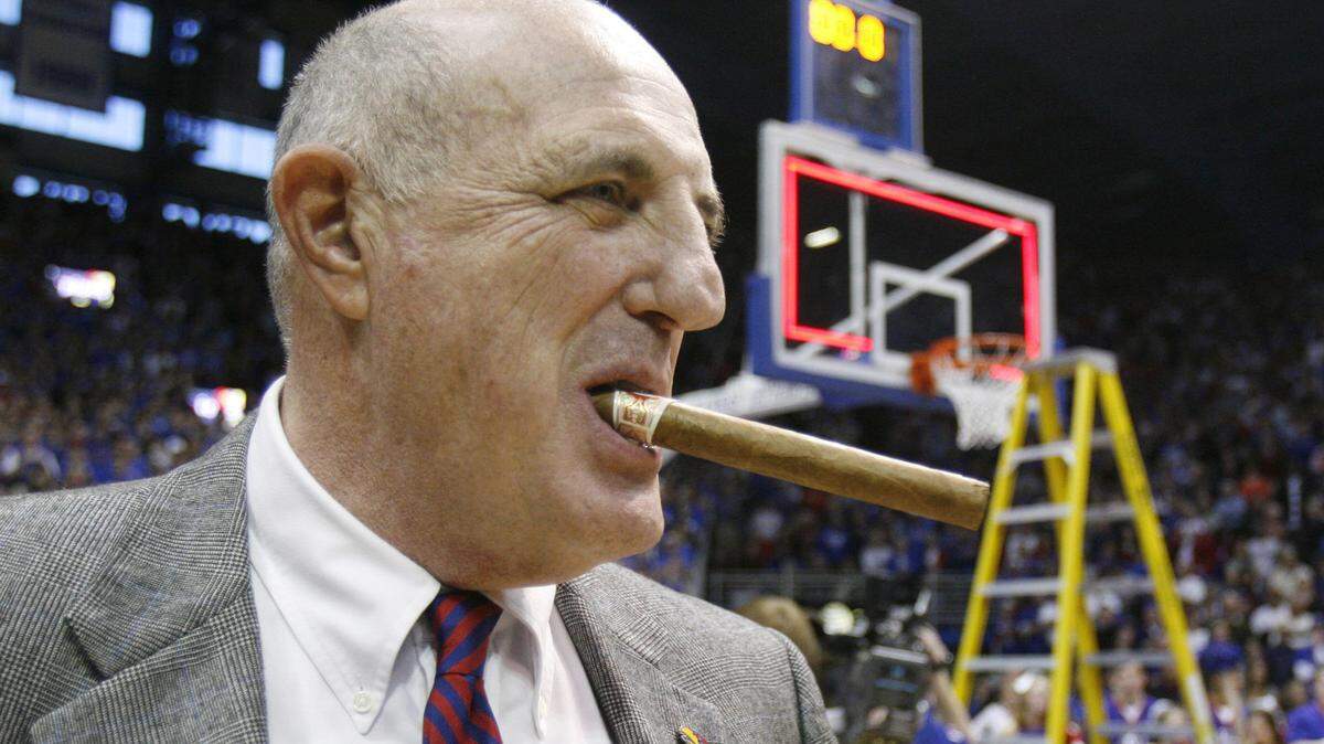 Kansas Jayhawks athletic director Lew Perkins enjoys a victory cigar after a basketball win over Texas on March 3, 2007.