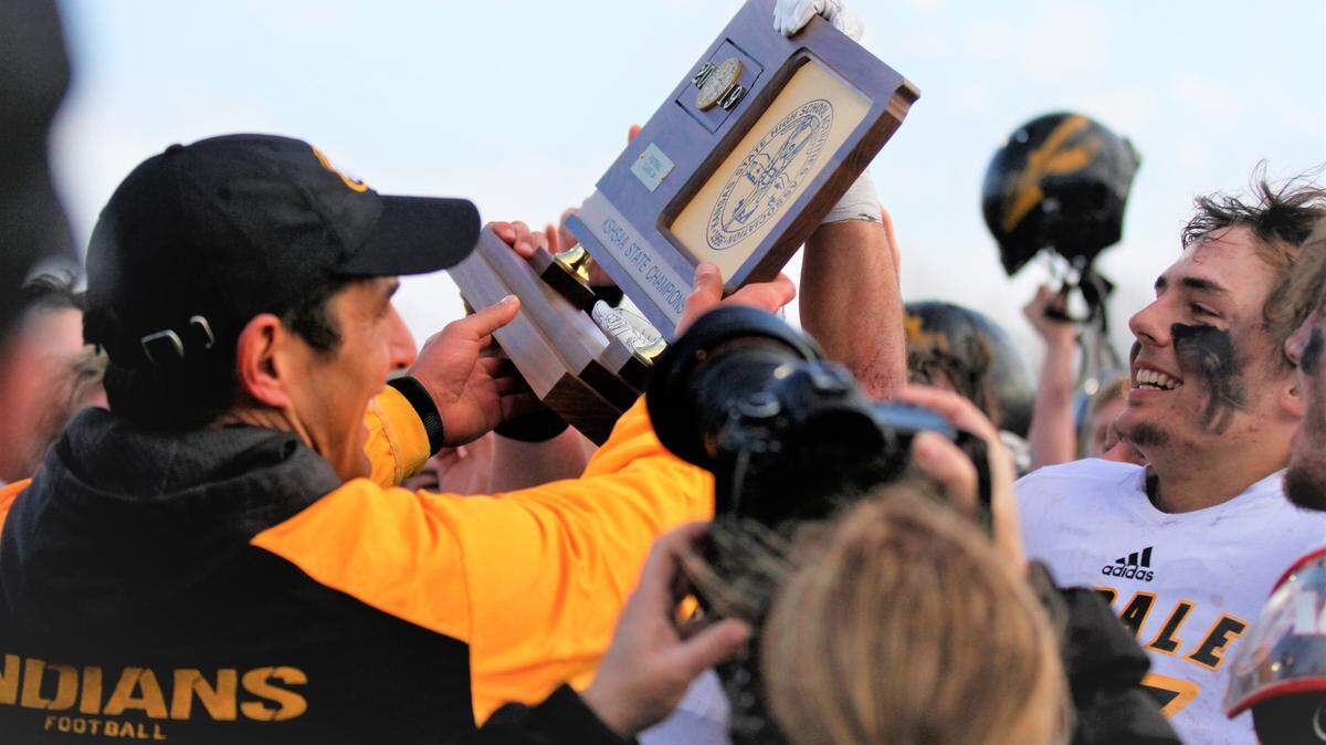 Andale coach Dylan Schmidt and senior quarterback Easton Hunter hoist the 2019 Kansas Class 3A state championship trophy.