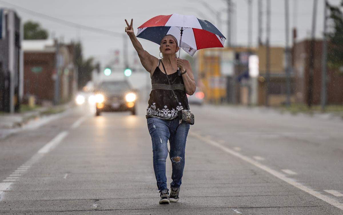 The "Families Belong Together" protest gathered at 9 a.m. in severe weather at 21st and Broadway on June 14, with plans to march down Broadway to Central. Rain and lightning delayed their start, but not for Joann Montanez, who said that families being ripped apart don't care about bad weather. So she set off alone down Broadway, with cars honking and driving around her. At one point, a law enforcement officer pleaded with her to stay out of the street, but Joann was determined, claiming the parade permit was good from 9 a.m. to noon. The rest of the protestors, about 75 to 100, began their march an hour later, under police escort.