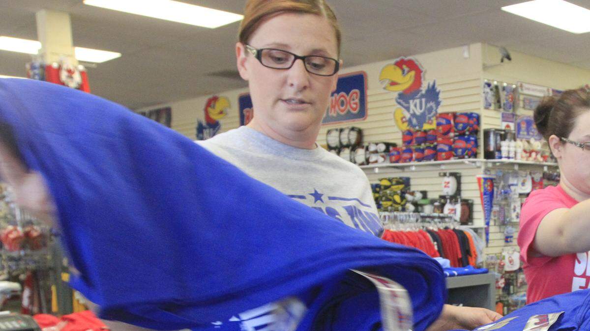 Valerie Becker, left, Sports Time Fan Shop manager, and Shaena Garrity, inventory manager, organize a new shipment of Kansas City Royals gear that just arrived at the NewMarket Square store Monday afternoon. (Oct. 6, 2014)