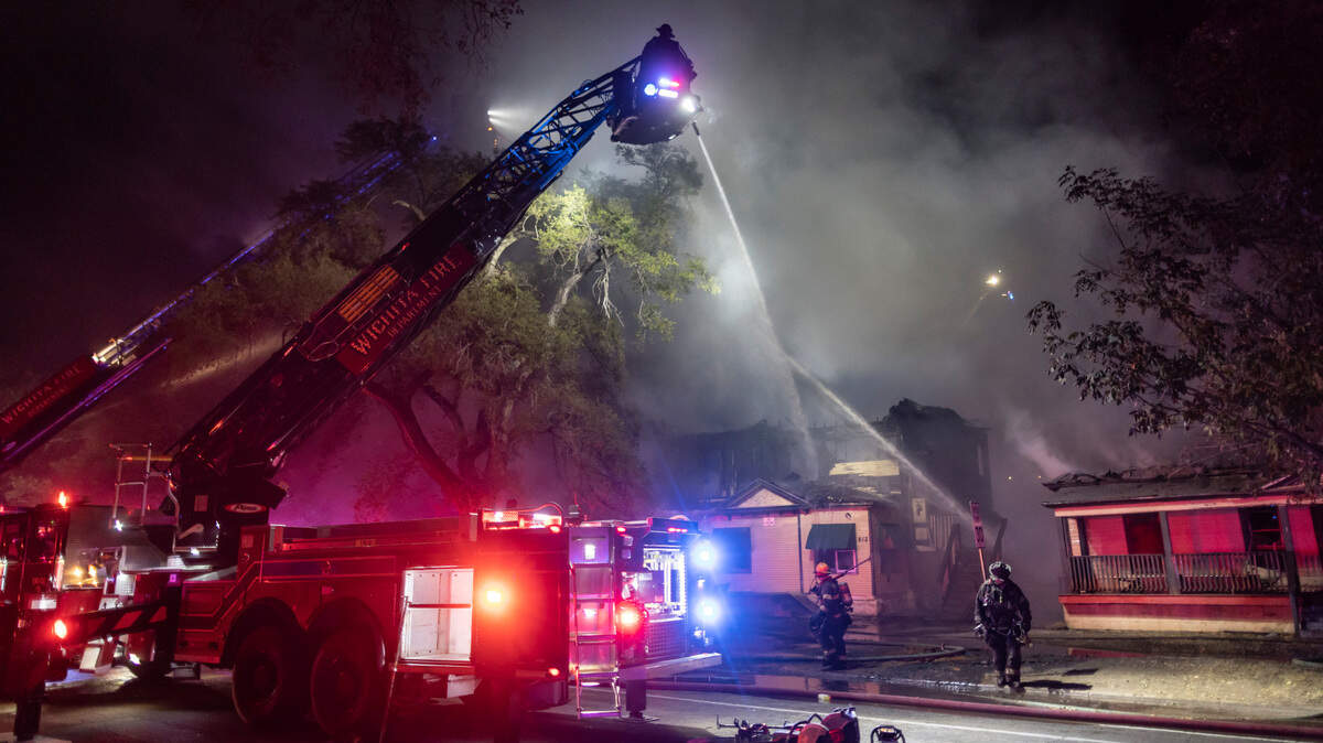 Firefighters pour water on the scene of a large fire that destroyed numerous structures just north of Murdock and Market on Saturday night.