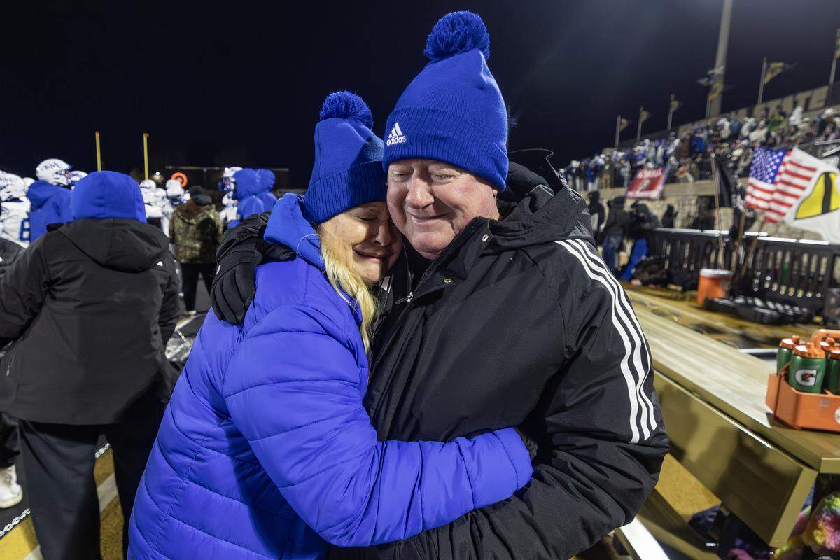 Kapaun head coach Weston Schartz is hugged by his tearful wife, Nancy, moments before Schartz led Kapaun Mt. Carmel to the 4A state title on Saturday. This was Schartz’s first state championship in nearly 40 years of coaching. Kapaun defeated Bishop Miege 56-21.