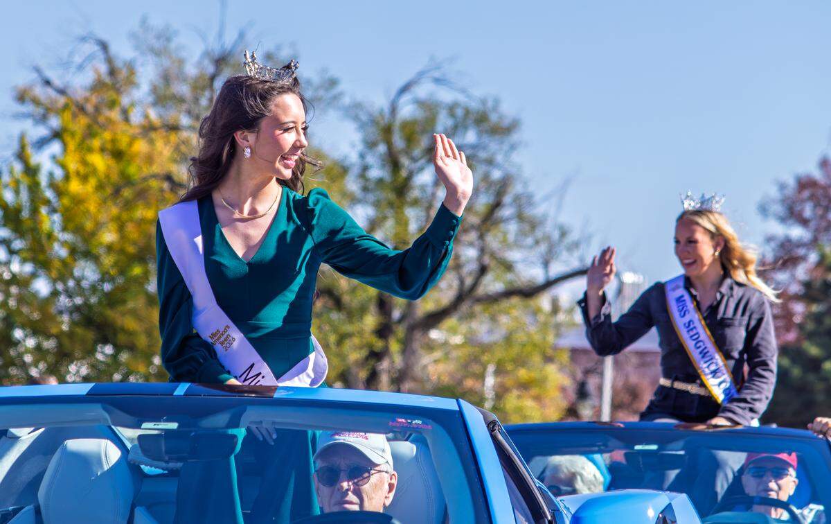 Winners of local, regional and national pageants wave as they ride along the Veterans Day parade route in downtown Wichita.