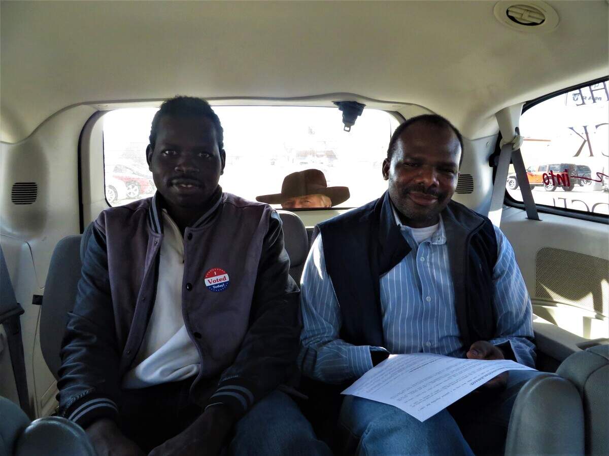 Mohamed Yaaqoub, left, and his friend and meat-packing-plant co-worker, Ezedeen Younes, ride to the polls in a Dodge City Convention and Visitors Bureau van. Both voted, but had to vote provisional ballots because of ID issues.