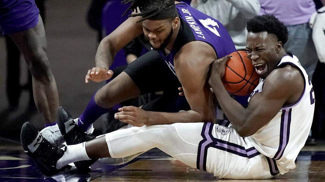 TCU center Eddie Lampkin (4) tries to steal the ball from Kansas State forward Kaosi Ezeagu during the second half of an NCAA college basketball game Wednesday, Jan. 12, 2022, in Manhattan, Kan. (AP Photo/Charlie Riedel)