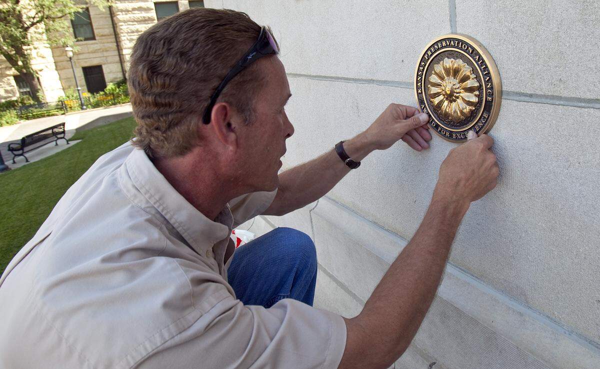 Chuck Carson of Luminous Neon Art and Sign Systems installed an Award for Excellence in Rehabilitation from the Kansas Preservation Alliance for the former Carnegie Library in 2010.