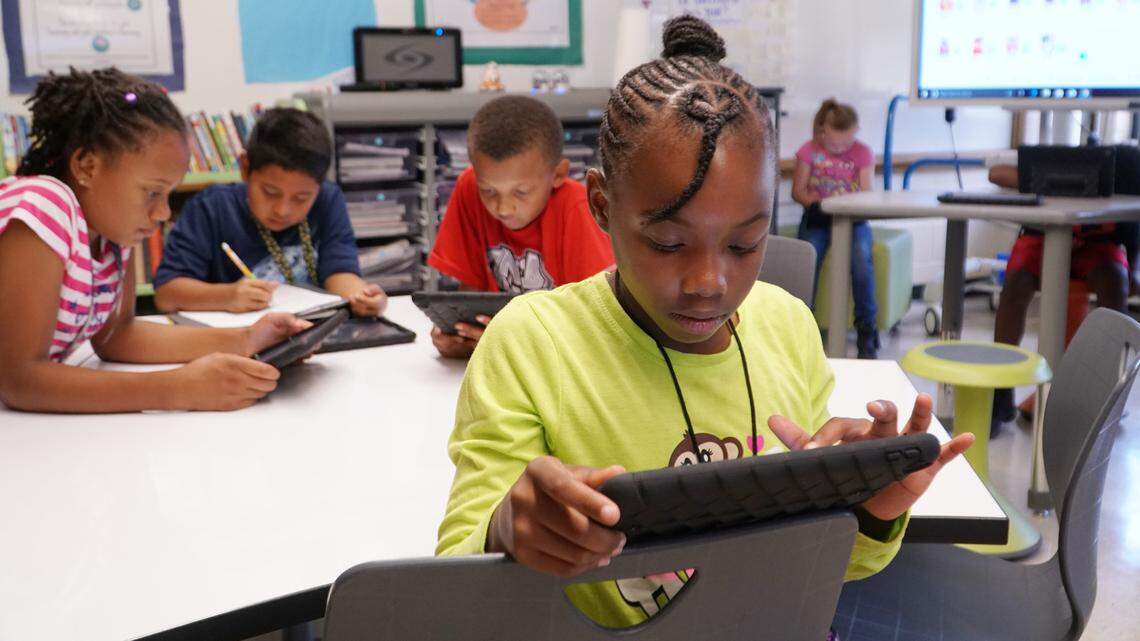 Zenia Quinn, a fourth-grader in Courtney Allen’s class at L’Ouverture Computer Technology Magnet Elementary School, uses her iPad during a reading lesson.