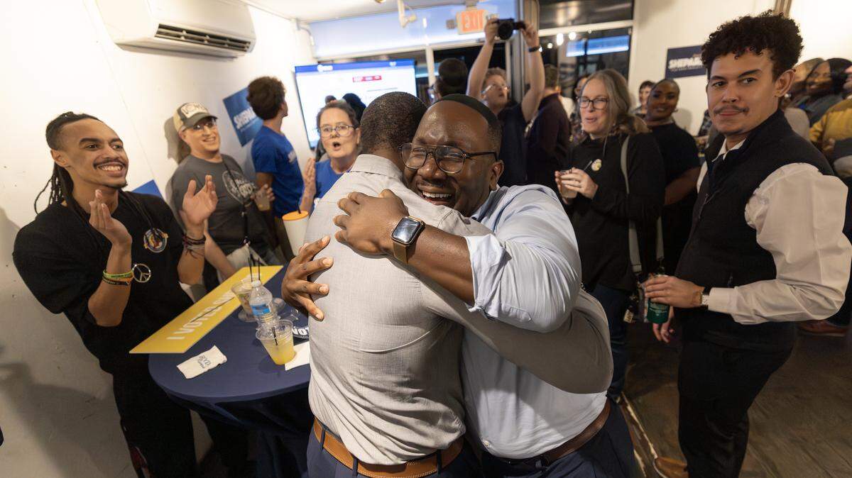 Joseph Shepard hugs incumbent District 1 City Council member Brandon Johnson after updated results showed Shepard with a sizable lead over opponent LaWanda DeShazer.