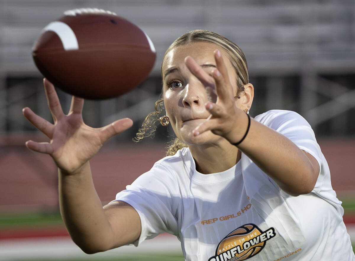 Heidi Williams catches the ball during pass and catch drill at Maize High’s flag football practice in August.