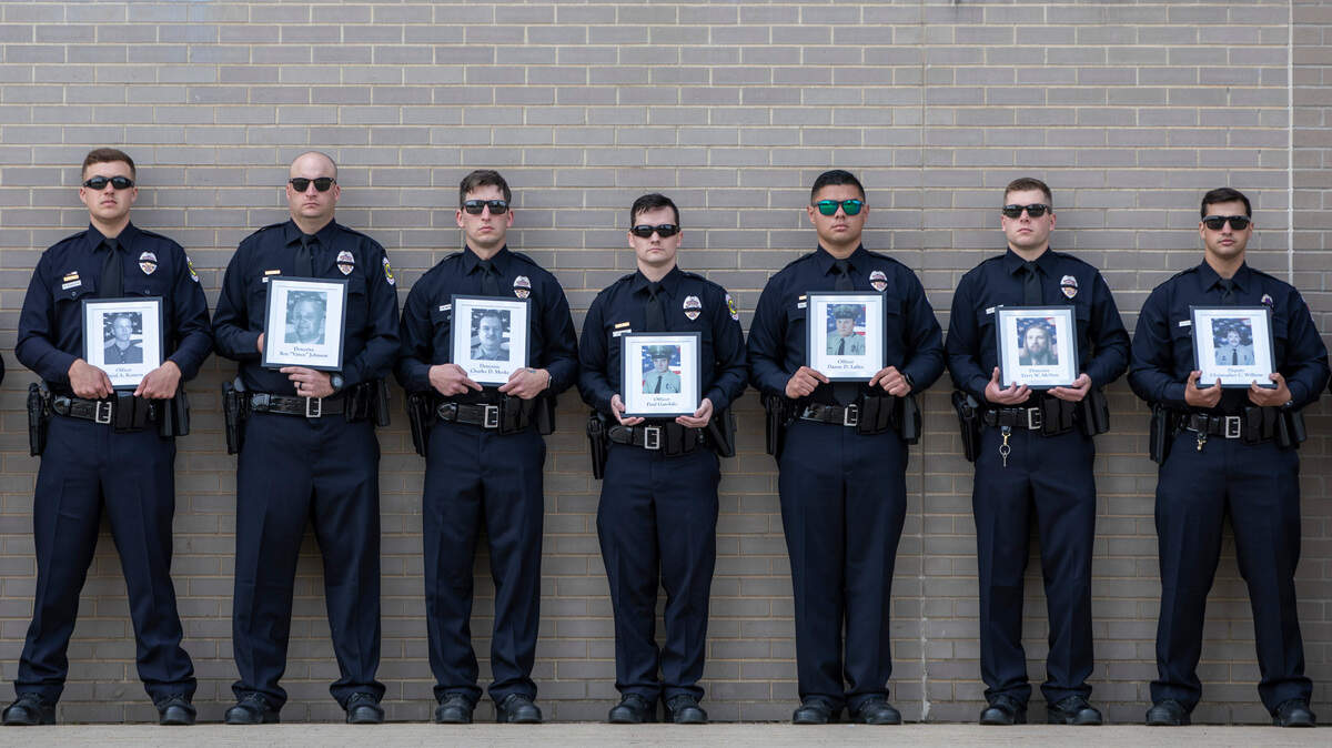 Members of the Wichita Police Department lined up last May to hold photographs of local law enforcement officers who have died in the line of duty in Sedgwick County. A memorial to honor police and sheriff personnel who have died in the line of duty will again be held outside City Hall at 10 a.m. Friday.