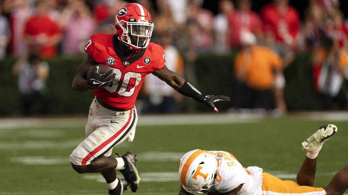 Georgia running back Daijun Edwards (30) runs away from Tennessee defensive back Doneiko Slaughter (0) after making a catch during the first half of an NCAA college football game Saturday, Nov. 5, 2022 in Athens, Ga. (AP Photo/John Bazemore)