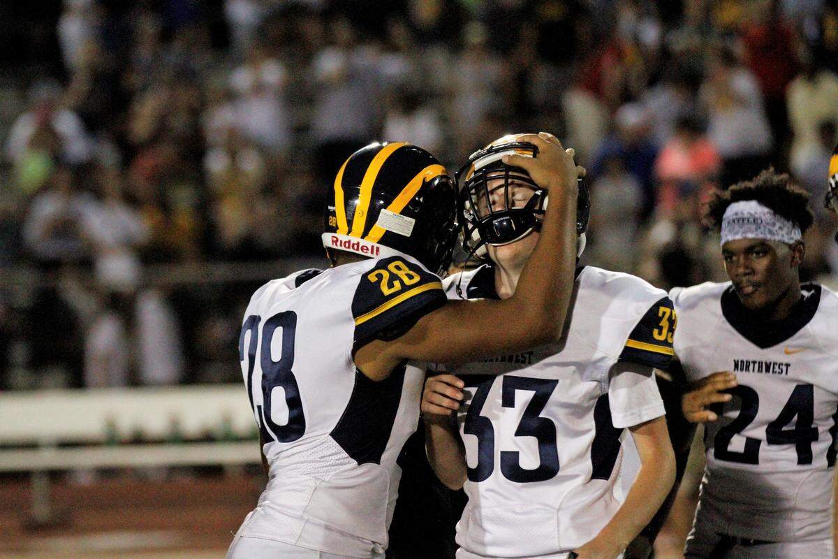 Wichita Northwest junior receiver Xavier Lopes (28) hugged sophomore kicker Carson Arndt (33) after the Grizzlies’ 23-22 last-second victory over Bishop Carroll on Friday night. (Aug. 31, 2018)