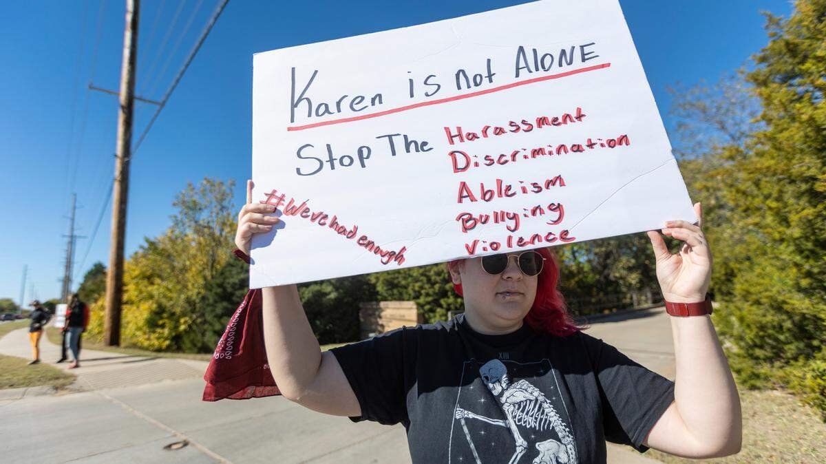 Rexhd Martin holds up a sign during a protest near the Hughes Metroplex on Friday. Martin and other protesters were outside of the inauguration event for new Wichita State President Richard Muma to bring attention to a federal lawsuit brought upon the university by Karen Countryman-Roswurm.