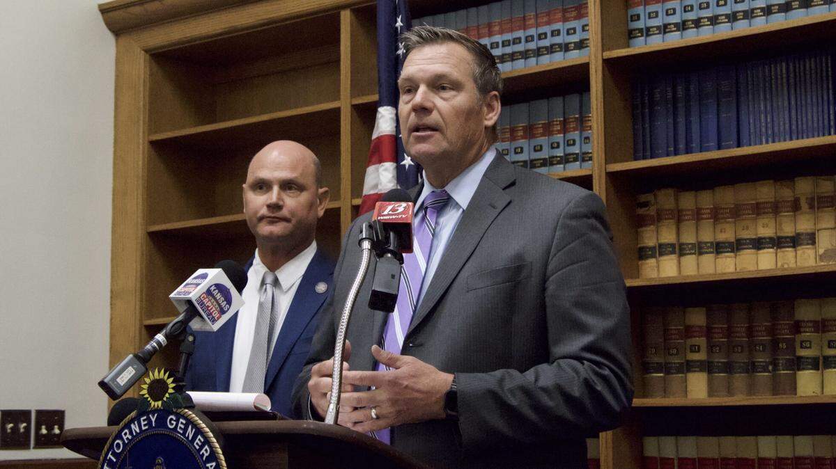 Kansas Attorney General Kris Kobach, at the podium, and Secretary of State Scott Schwab announced felony charges against Joe Ceballos, currently the Coldwater, Kansas, mayor. He is accused of voter fraud.