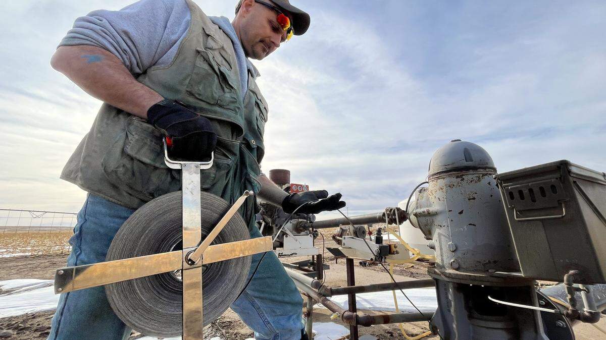Brownie Wilson of the Kansas Geological Survey uses a metal measuring tape to determine the depth of the aquifer’s water level in western Kansas. Statewide aquifer levels dropped by nearly two feet over the past year — this third-largest decline since the 1990s.