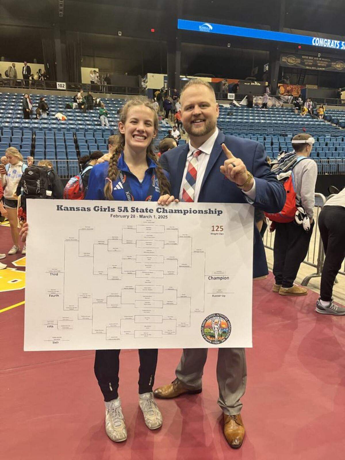 In her first year of wrestling, Kapaun Mt. Carmel junior Courtney Nye won the 125-pound championship at the Class 5A state tournament this past Saturday. Nye (left) is pictured with Kapaun coach Quinton Burgess (right) following her title win.