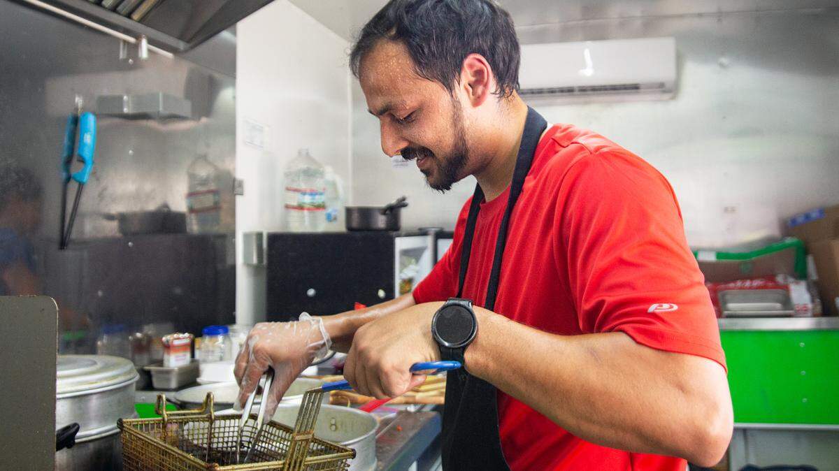 Unnat Ghimire fries up momos for customers outside of the Sky Lounge during a local beer pop-up. Ghimire, owner of The Momo Stop, takes his food truck to different parts of the city for events.