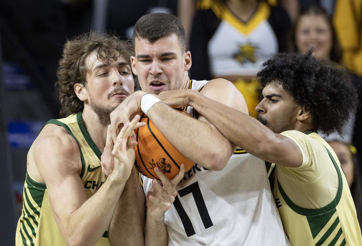 Wichita State’s Matej Basnjak is swarmed by Charlotte defenders Nik Graves, right, and Dean Reiber during the second half of their game on Tuesday night at Koch Arena.