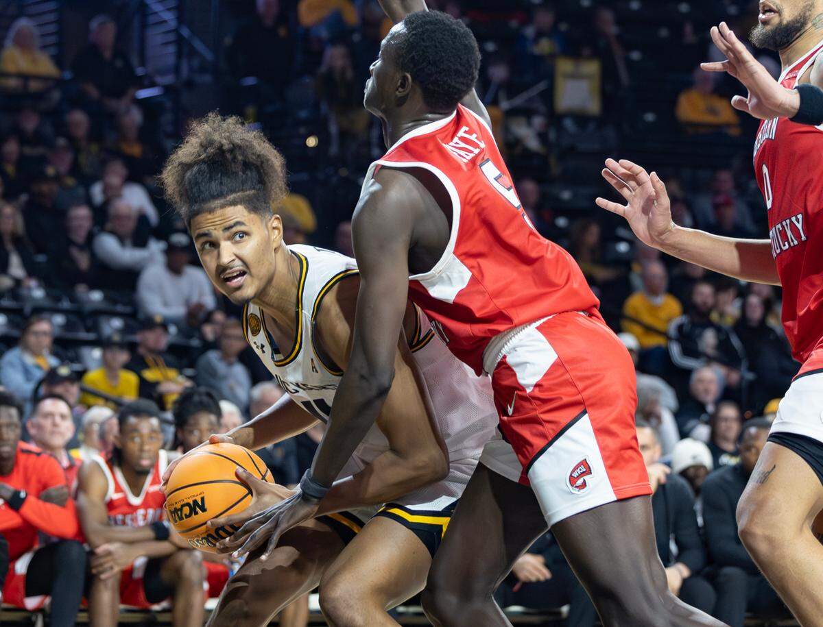 Wichita State’s Kenny Pohto looks for a path to the basket against the defense of Western Kentucky’s Babacar Faye during the first half of their game Thursday night at Koch Arena. 