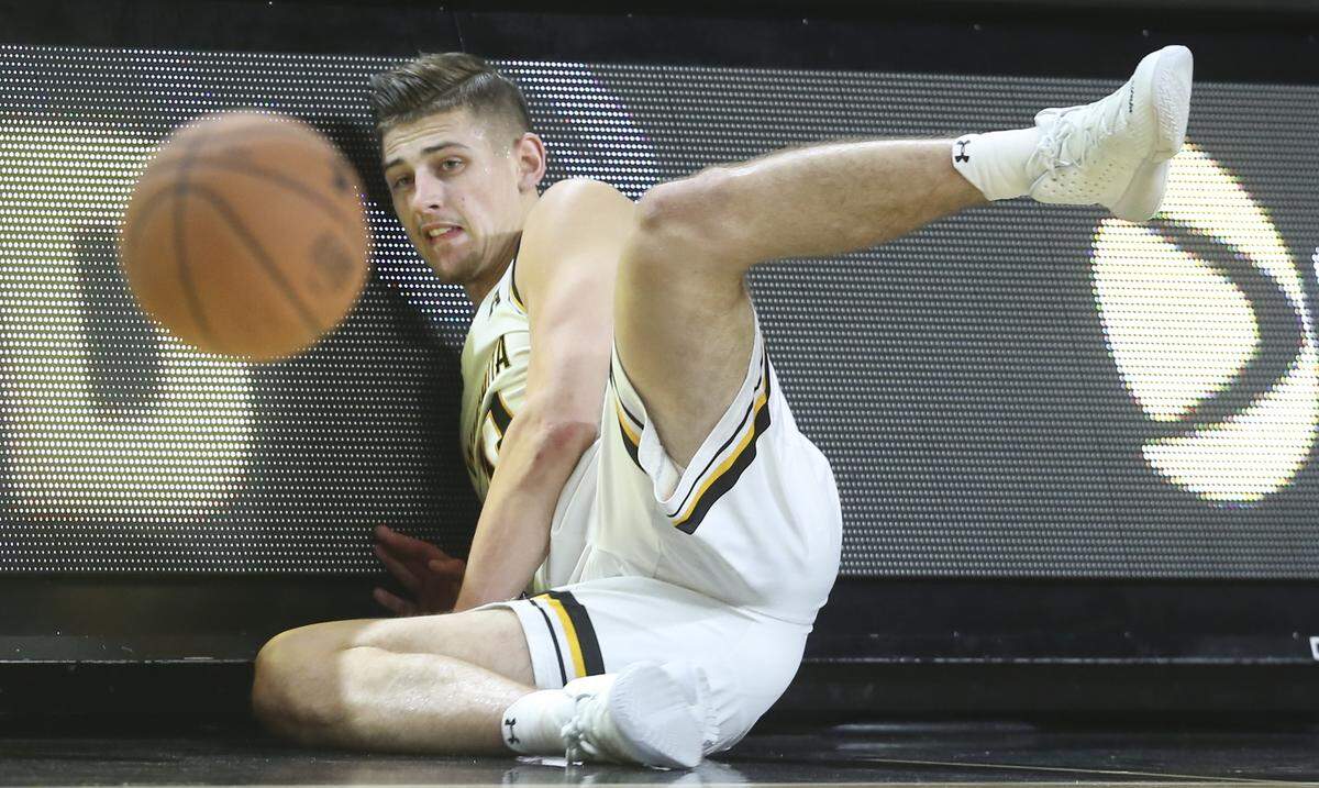 Wichita State’s Erik Stevenson, left, dives for a loose ball against Ole Miss during the first half on Saturday at Koch Arena. Stevenson cut his wrist on the play, requiring five stitches.