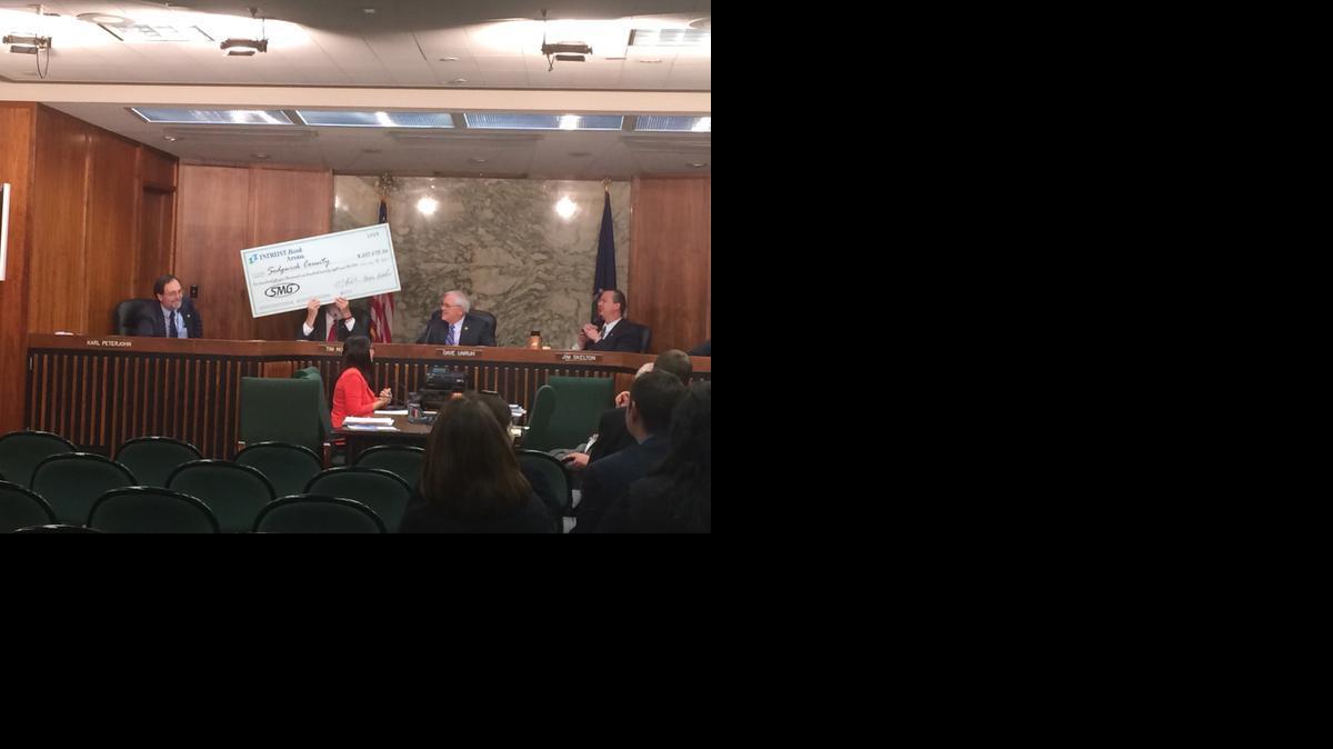 Intrust Bank Arena general manager A.J. Boleski presented Sedgwick County commissioners with an oversized check for $255,678, the county’s portion of profits last year. Commissioner Tim Norton, holding the check, jokingly asked if it came with an oversized deposit slip. (May 14, 2014)

