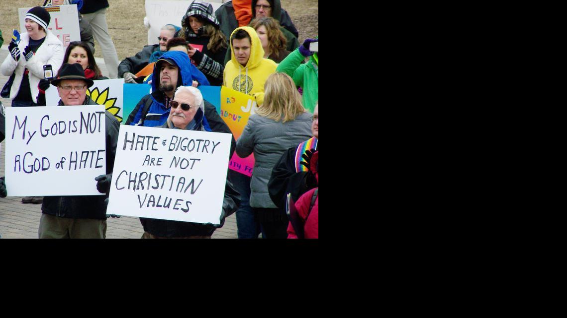 Paul Osgood, 67, and Jerry Cundiff, 74, hold signs protesting House Bill 2453 at the Kansas Statehouse. Osgood and Cundiff said they have been a committed couple for 38 years.

