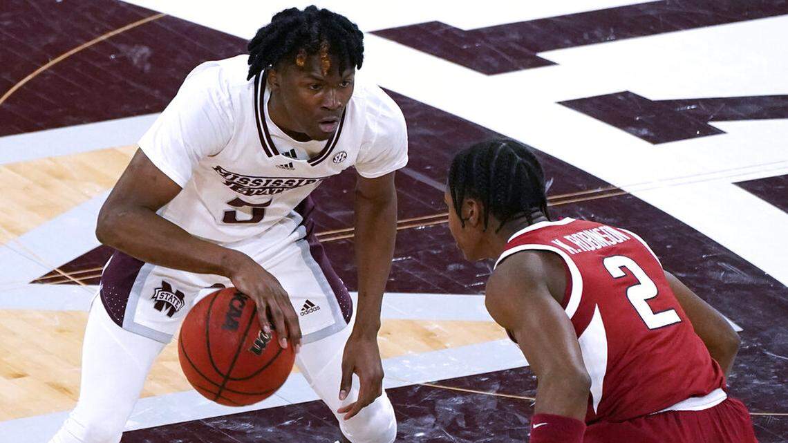 Mississippi State guard Cam Carter (5) attempts to dribble past Arkansas guard Khalen Robinson (2) during the first half of an NCAA college basketball game in Starkville, Miss., Wednesday, Dec. 29, 2021. (AP Photo/Rogelio V. Solis)