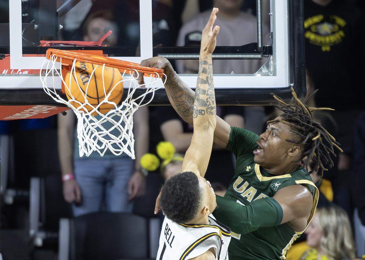 Ja’Borri McGhee dunks over Wichita State’s Xavier Bell during the second half on Thursday night at Koch Arena.