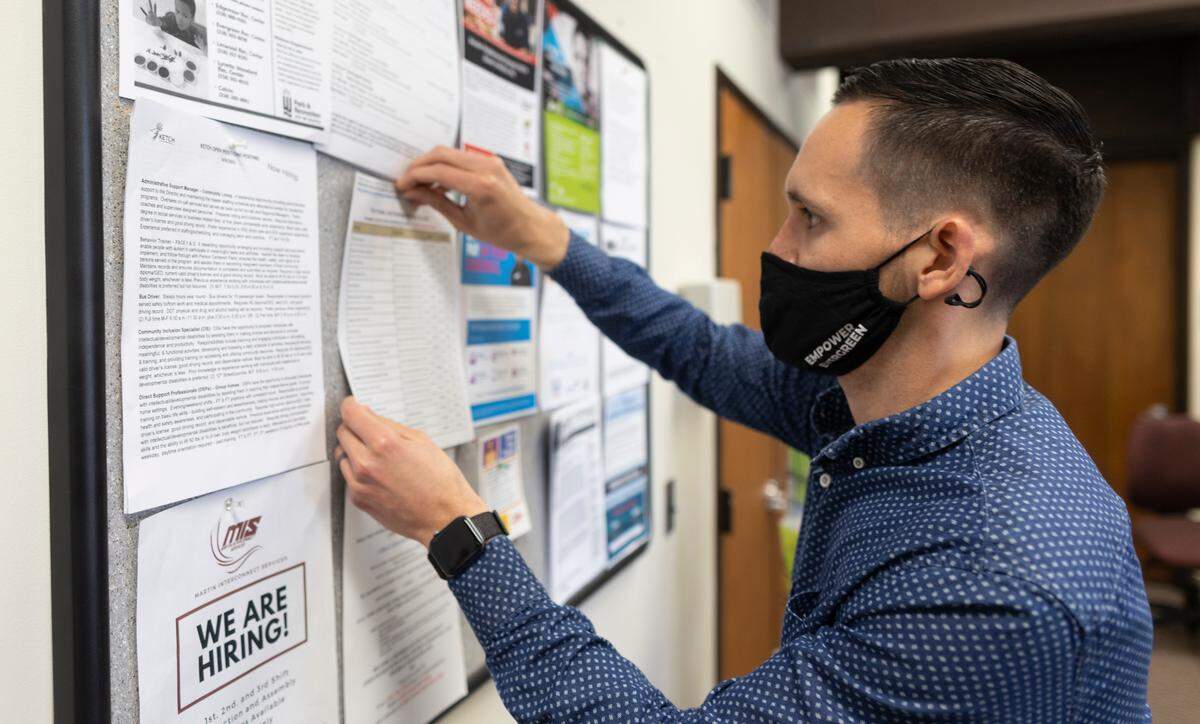 Ariel Rodriguez posts job openings on a bulletin board at the Evergreen Community Center last week. Rodriguez is the Executive Director of Empower Evergreen.
