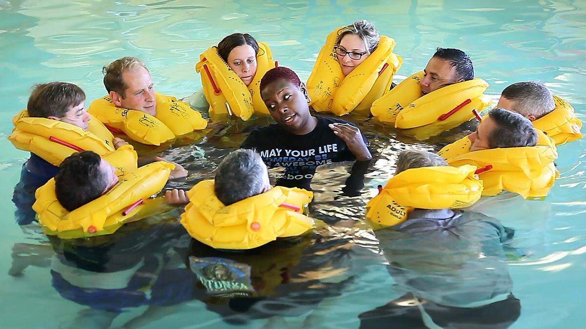 Mico Renee, an emergency procedure trainer for Aircare FACTS Training, center, instructs pilots and flight crew members during Bombardier’s Safety Standdown in a workshop on egress training in the Wichita Hyatt Regency pool in 2013.