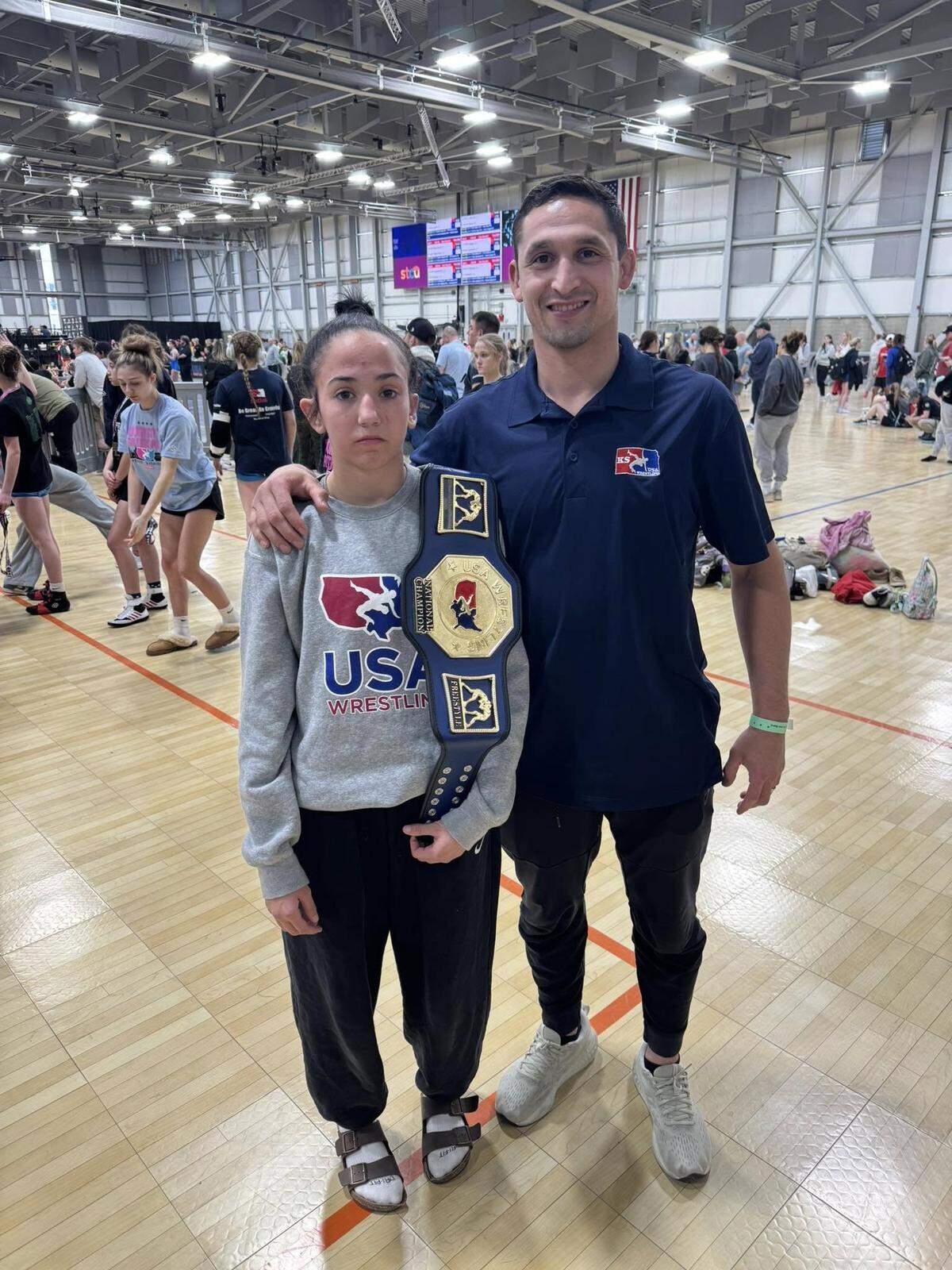 Wichita native Presley Beard poses for a picture with her coach after winning the 14-under, 105-pound national championship this past weekend in Spokane, Wash.