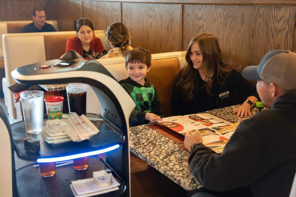 Greyson Smith smiles when his food is delivered by a robot at Ninza Sushi Bar at 13th and Tyler. Greyson was there with his parents Justina and Preston Smith. The robot has a catlike face when it moves and delivers food to customers, and it seems to enjoy being petted.
