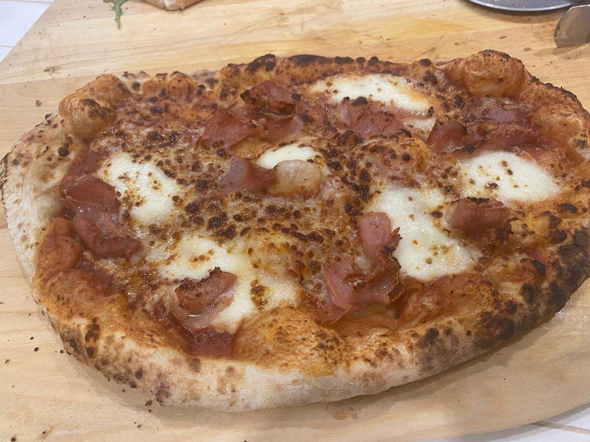A prosciutto-topped pizza made in an Ooni gas-powered pizza oven on Piatto dough