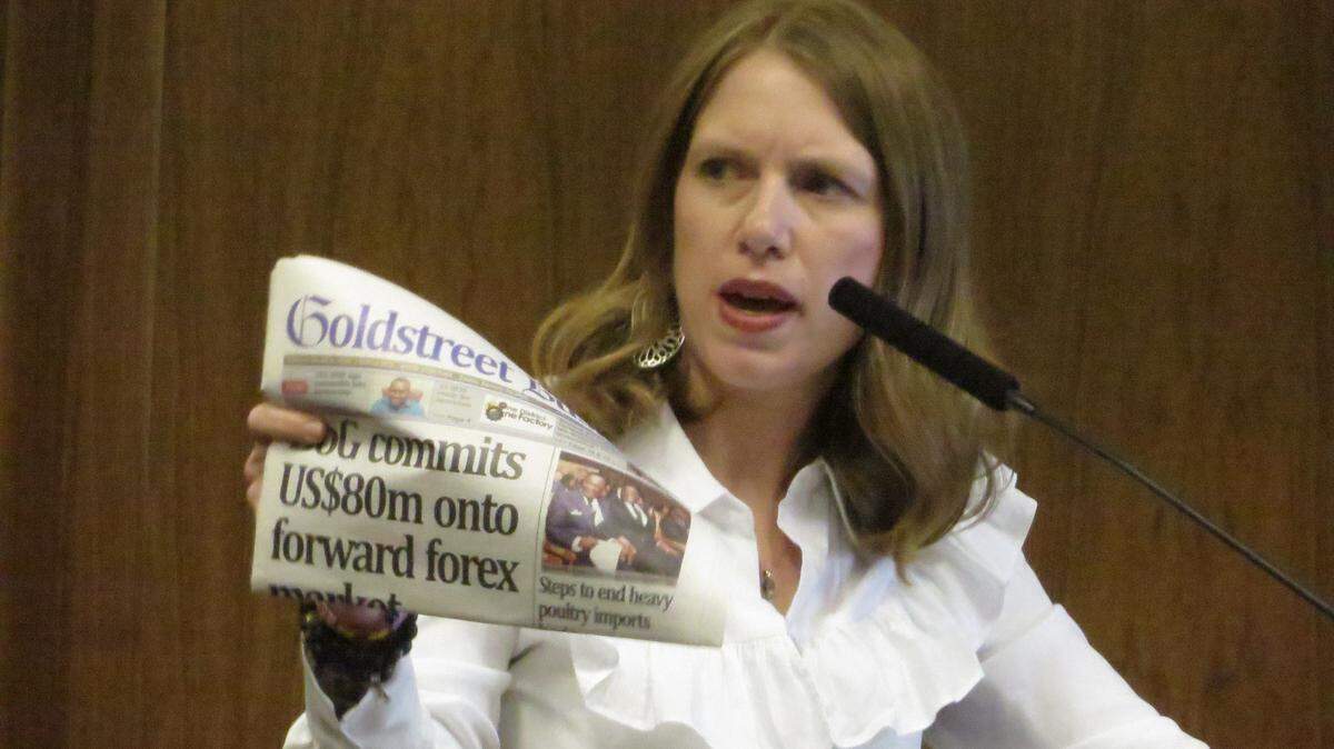 Sedgwick County Commissioner Lacey Cruse holds up a newspaper from Ghana during a presentation to county commissioners in 2020 about her trip to the African nation.