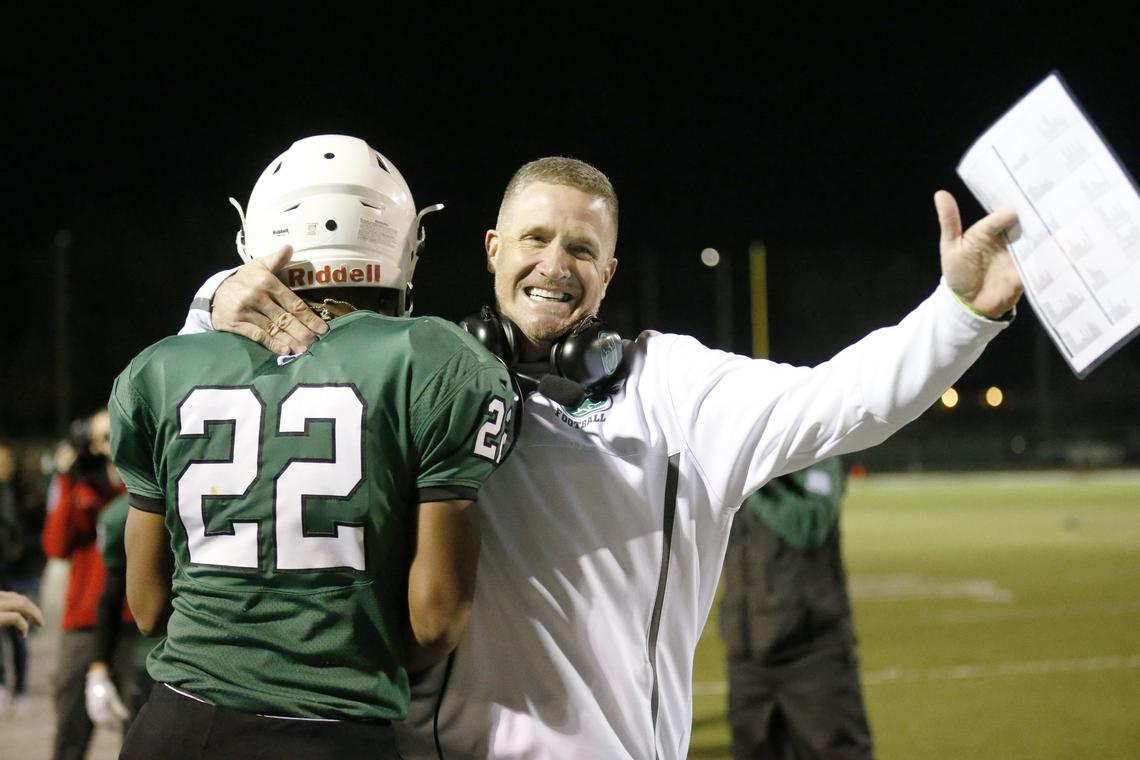 Derby head coach Brandon Clark celebrates with Tre Washington after Washington score on the second play of the night against Manhattan High. (November 16, 2018)