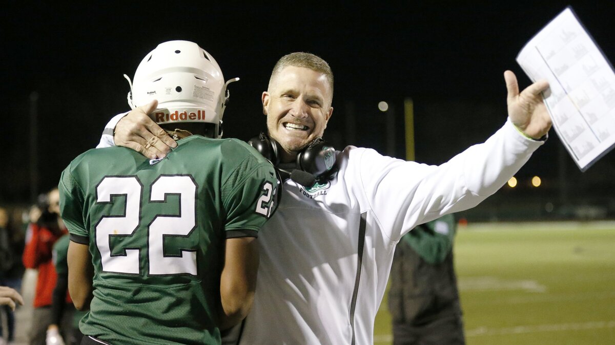 Derby head coach Brandon Clark celebrates with Tre Washington after Washington score on the second play of the night against Manhattan High. (November 16, 2018)
