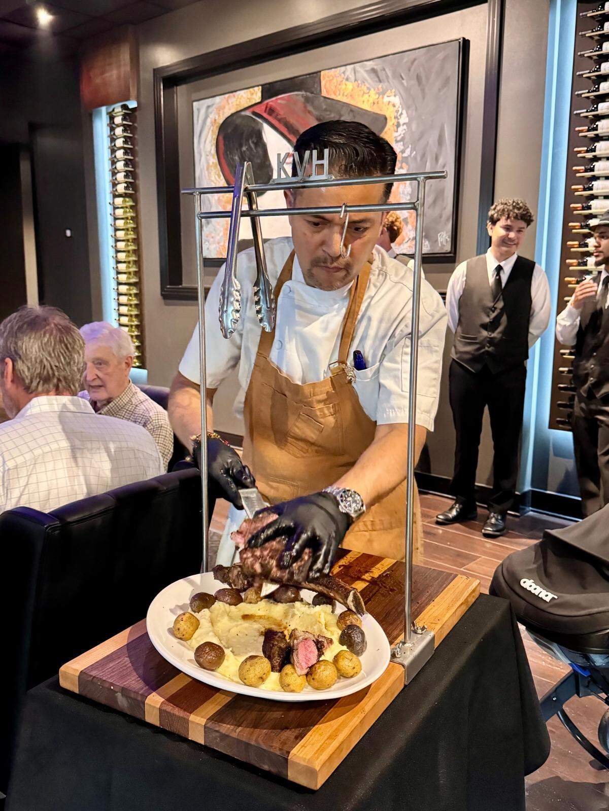 KVH chef Jorge Morales serves flaming tomahawk steaks table side. 