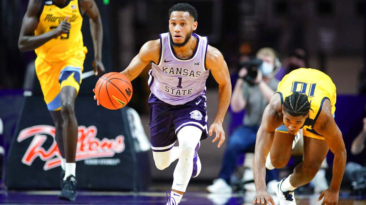 Kansas State guard Markquis Nowell (1) brings the ball up past Marquette forward Justin Lewis, right, and forward Kur Kuath during the second half of an NCAA college basketball game Wednesday, Dec. 8, 2021, in Manhattan, Kan. Marquette won 64-63. (AP Photo/Nick Krug)