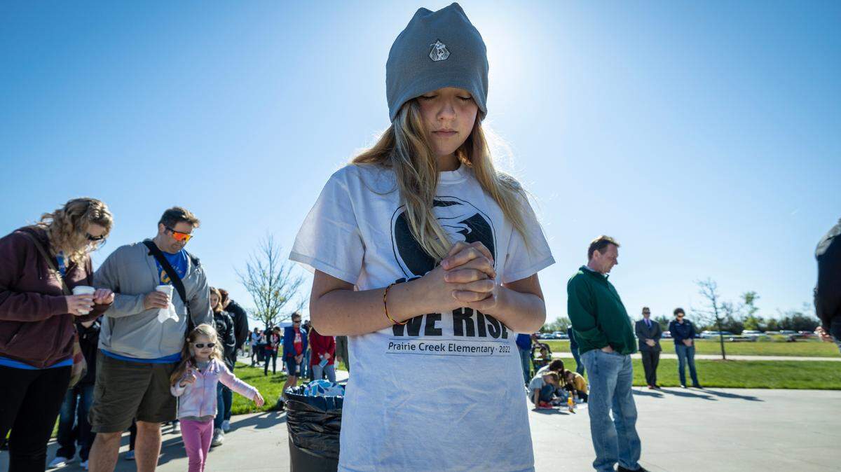 Finley Watson, a fourth grader at Andover’s Prairie Creek Elementary, takes a part in an opening prayer during a prayer breakfast and celebration at Andover’s Central Park on Saturday morning. The event was held to commemorate the first anniversary of a tornado that ripped through Andover, destroying dozens of homes and businesses. Watson’s school was heavily damaged by the tornado and a choir from Prairie Creek Elementary performed at the event.