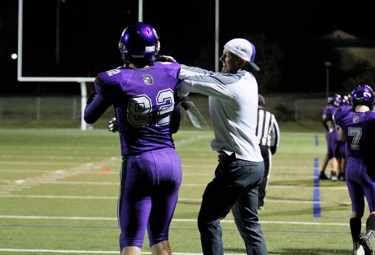 Offensive coordinator Trey Hall celebrates with each offensive player after every touchdown the Warriors score.